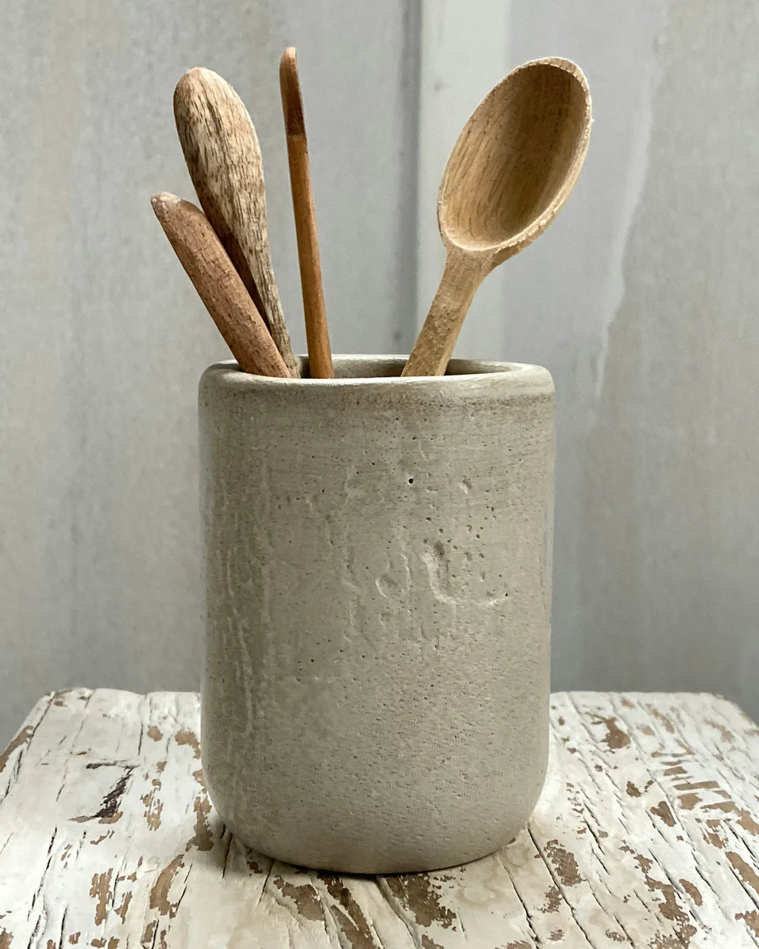 a metal bucket with wooden spoons