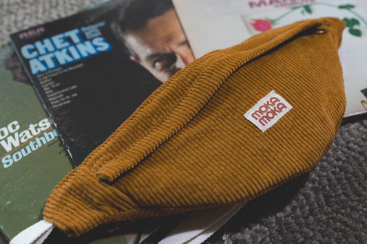 a brown hat sitting on top of a pile of books