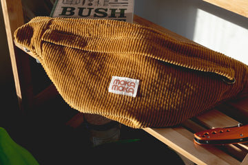 a brown purse sitting on top of a wooden shelf