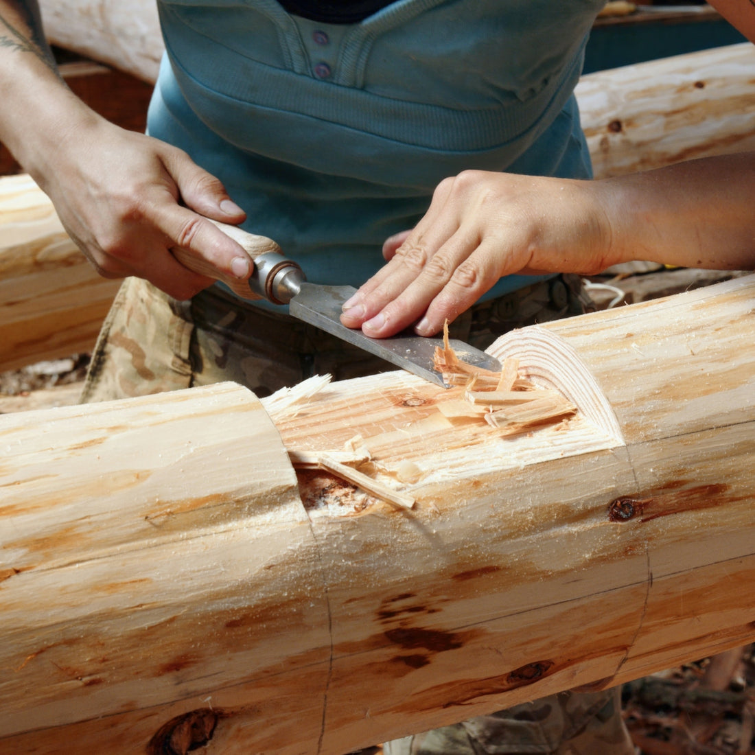 a person cutting a piece of wood with a knife