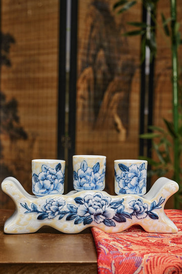 A group of four blue and white cups sitting on top of a wooden table