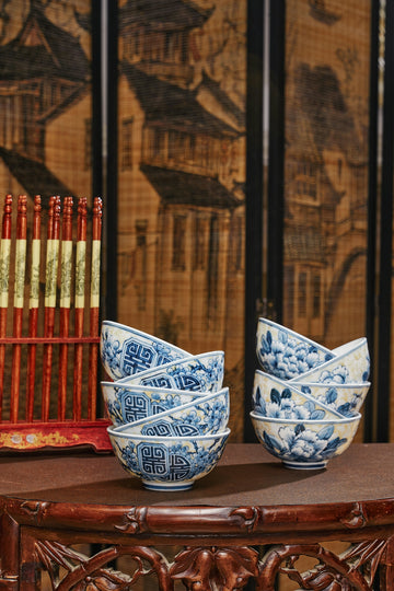 A wooden table topped with blue and white bowls