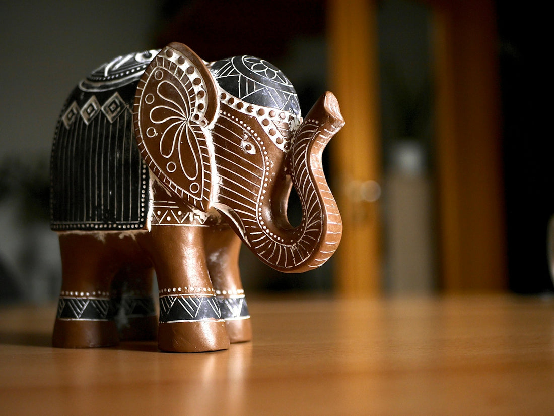 Ornate wooden elephant figurine on a wooden surface
