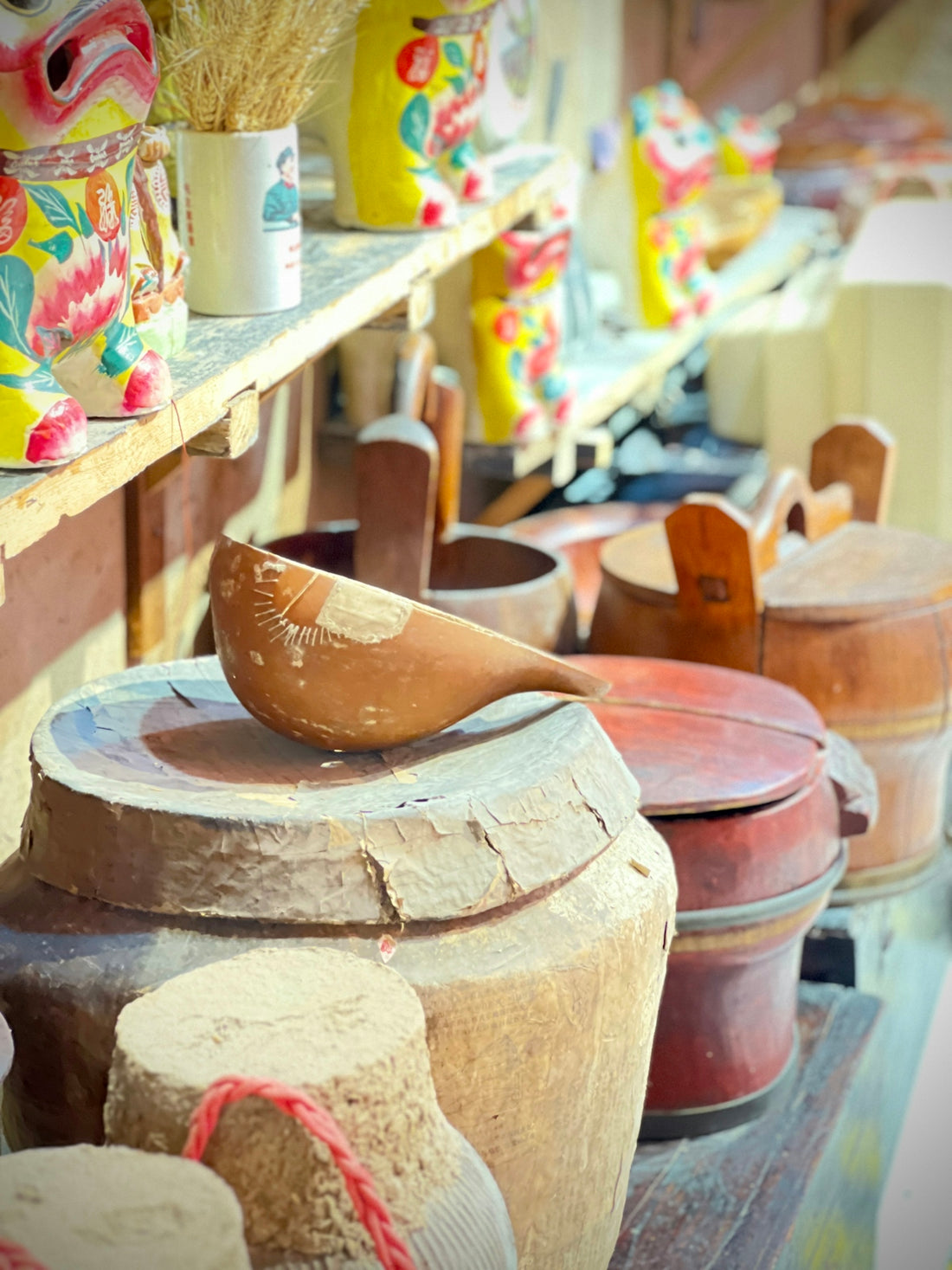 Wooden utensils and colorful pottery on shelves